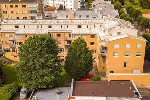 Flerbostadsfastighet med gul tegelfasad och ljust plåttak | Nivika Fastigheter AB (publ)