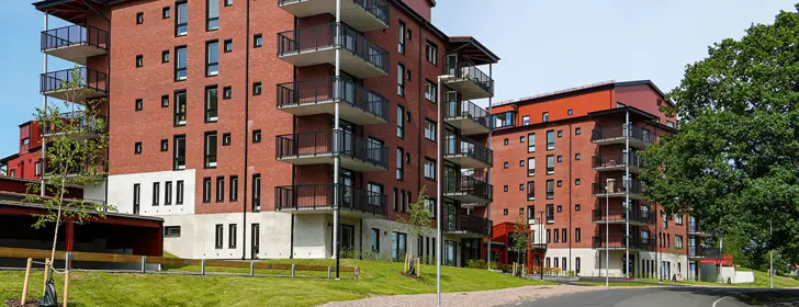 Flerbostadshus med tegelfasad, svarta fönster samt balkonger | Nivika Fastigheter AB (publ)