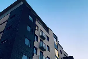 Fastighet med svart fasad, svarta fönster och glasbalkonger | Nivika Fastigheter AB (publ)