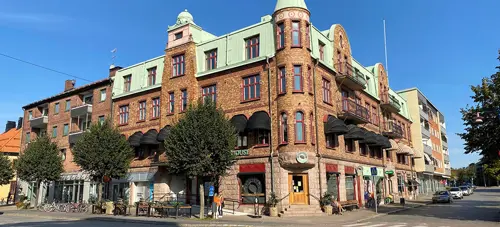 Fastighet med röd tegelfasad och grönt koppartak | Nivika Fastigheter AB (publ)