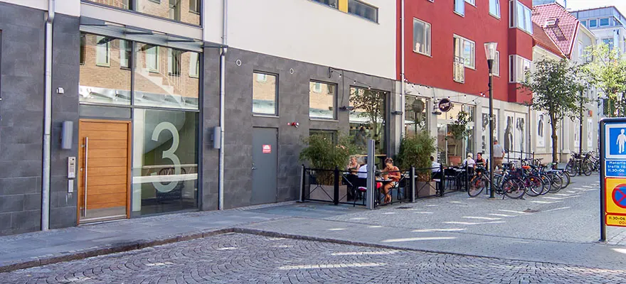 Fasaden på fastigheten är grå, vit och röd, gatan är av kullersten | Nivika Fastigheter AB (publ)