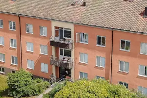 Flerbostadshus och Kommersiell fastighet med rosa putsad fasad, vita fönster och rött tegeltak | Nivika Fastigheter AB (publ)