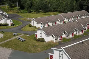 Flerbostadsfastighet med vit fasad och mörkt tegeltak, bild tagen ovanifrån | Nivika Fastigheter AB (publ)