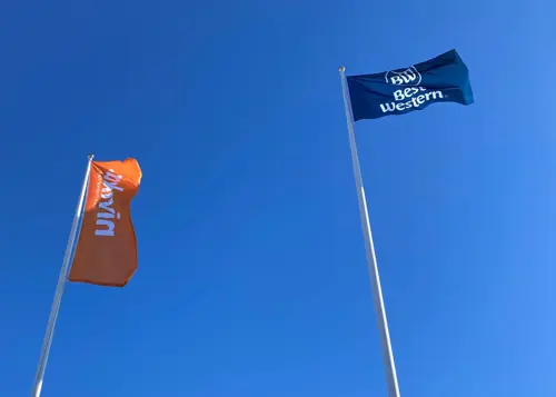 Två flaggor med blå himmel i bakgrunden | Nivika Fastigheter AB (publ)