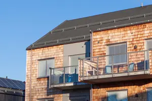 Flerbostadshus med röd tegelfasad och svart tak | Nivika Fastigheter AB (publ)