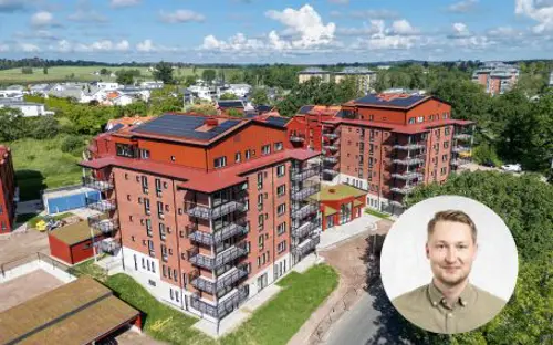 Flerbostadsfastighet med röd fasad och rött tak, svarta balkonger | Nivika Fastigheter AB (publ)