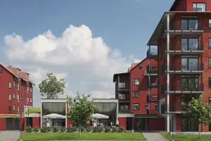 Flerbostadsfastighet med röd fasad, svarta fönster samt balkonger | Nivika Fastigheter AB (publ)