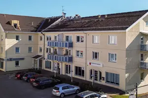 Flerbostadshus med ljus fasad och rött tegeltak | Nivika Fastigheter AB (publ)